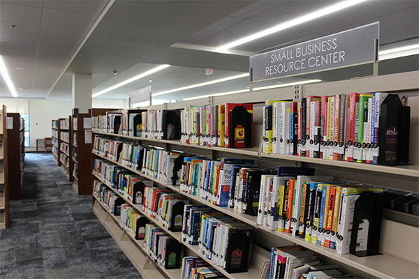 book shelves filled with books with a sign that reads "small business resource center"