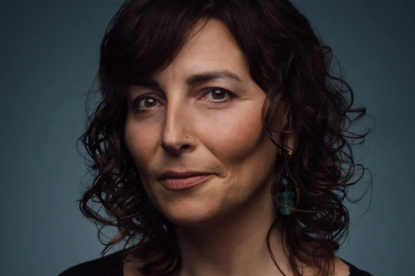 woman with brown curly hair looking at camera