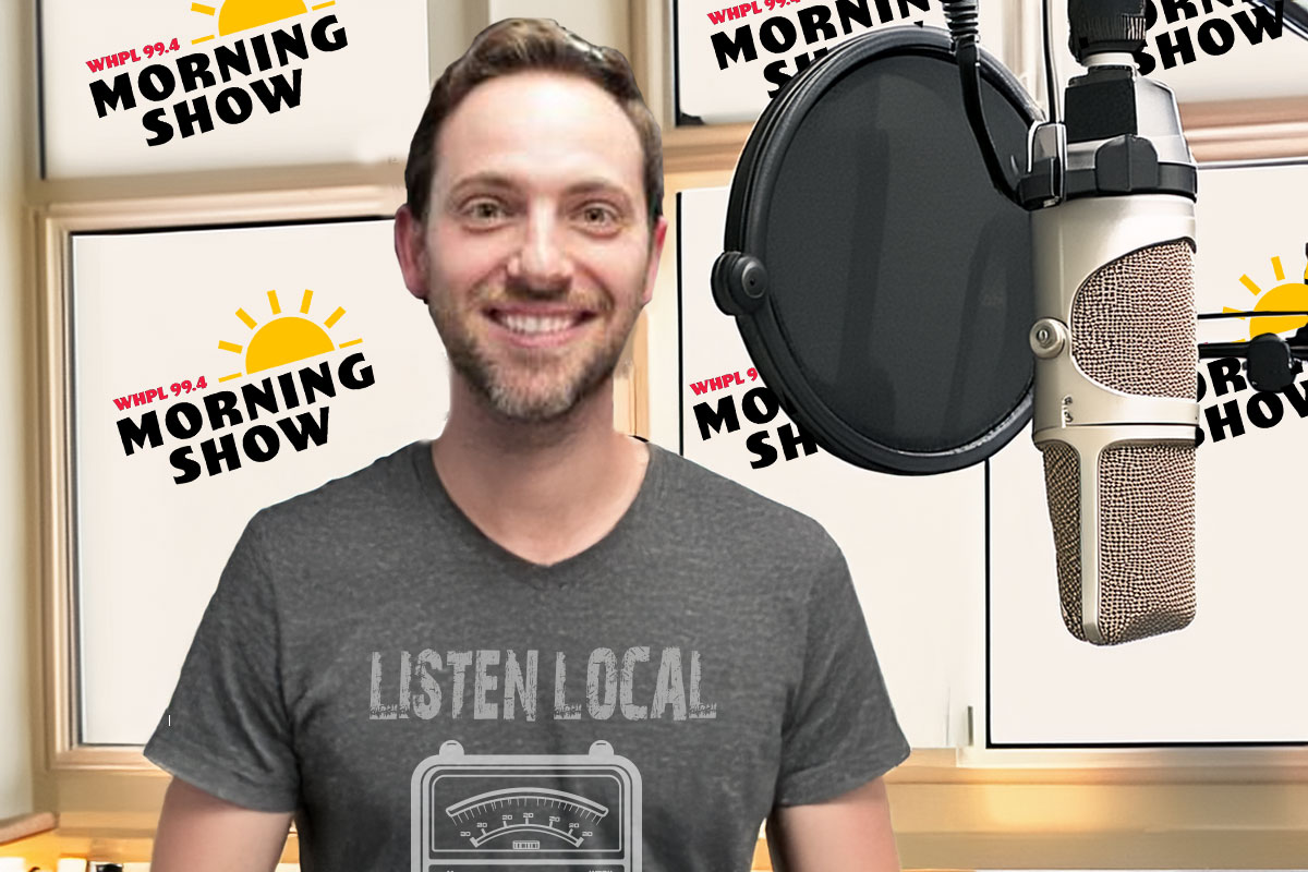 man smiling at camera in front of microphone with tshirt that says listen local