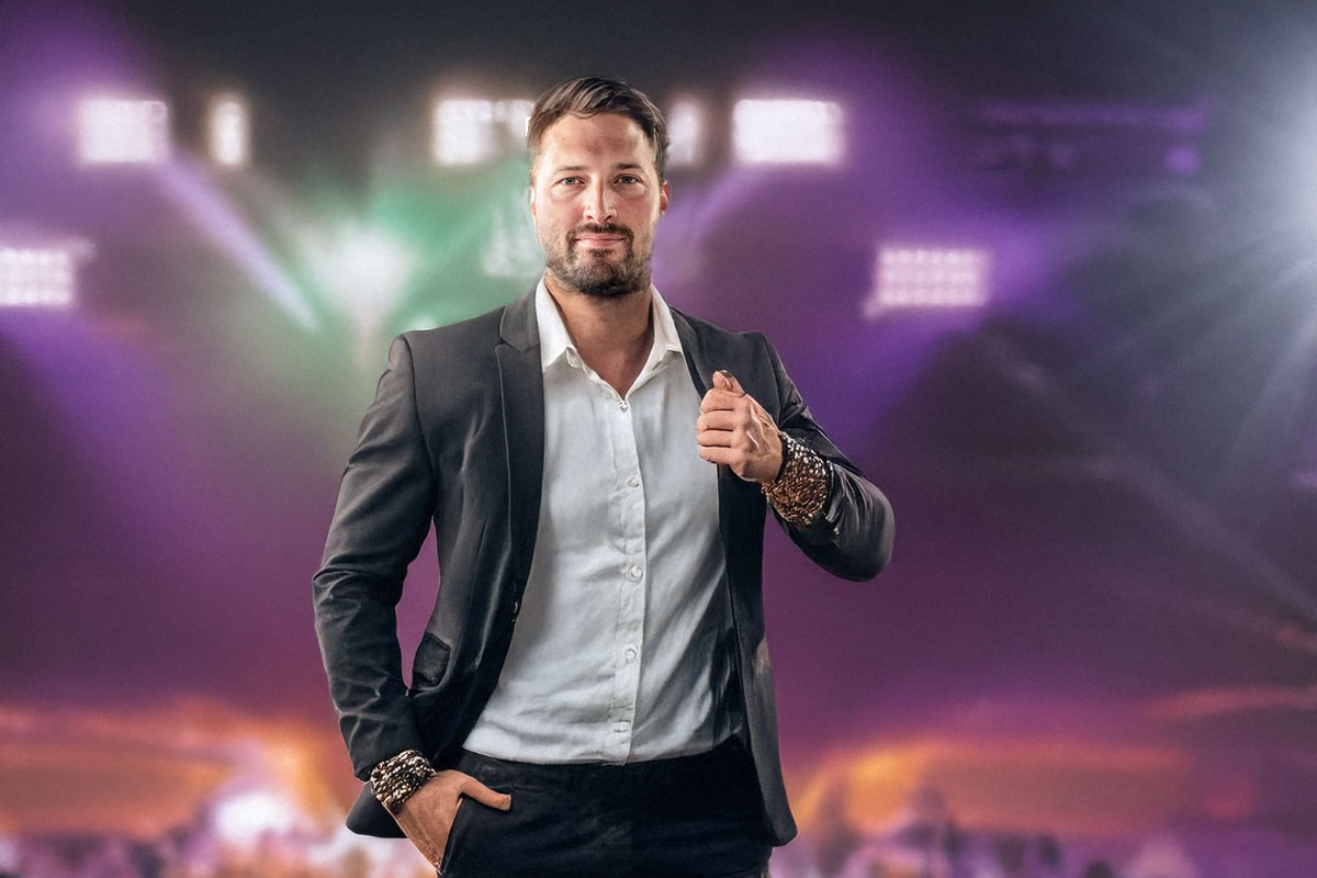 man wearing a suit in front of a stage