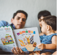 a latino mother and father reading a picture book to their infant