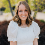 woman with long blond hair wearing white dress and smiliing