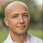 bald man wearing button up shirt looking at camera