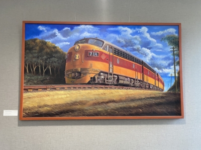 Large painting of a Milwaukee Road train with engine and passenger cars.