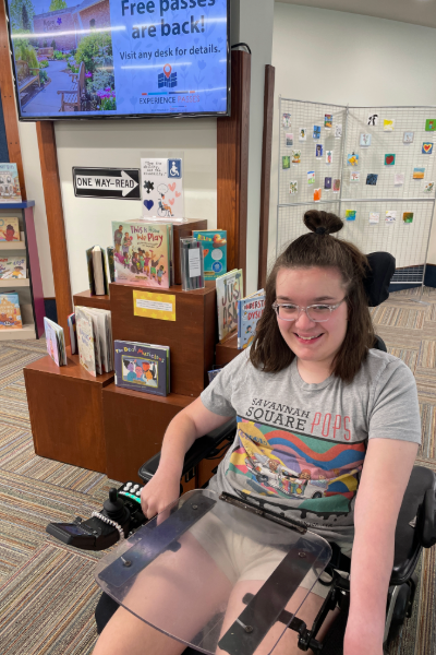young woman with dark hair in a wheelchair at the library