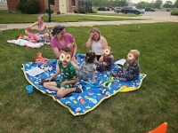 children reading on blanket outside
