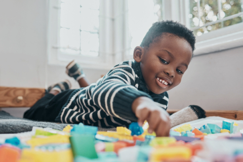 young african american boy playing with colorful blocks