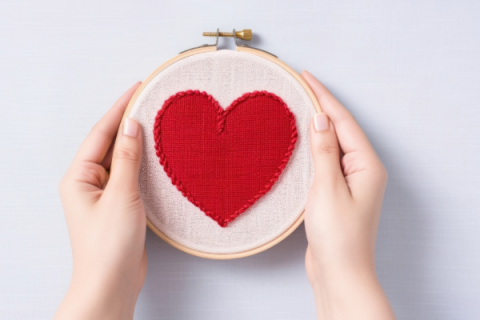 hands holding cross-stitched heart