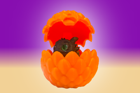 Black dragon emerging from orange egg