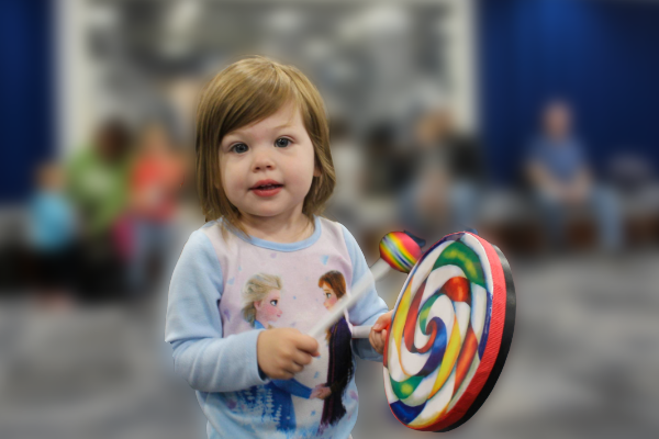 little girl holding a colorful drum
