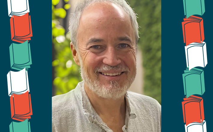 man with white hair and beard smiling at camera