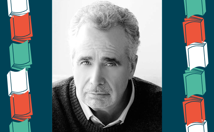 black and white phot of man with gray hair wearing a sweater and looking at the camera