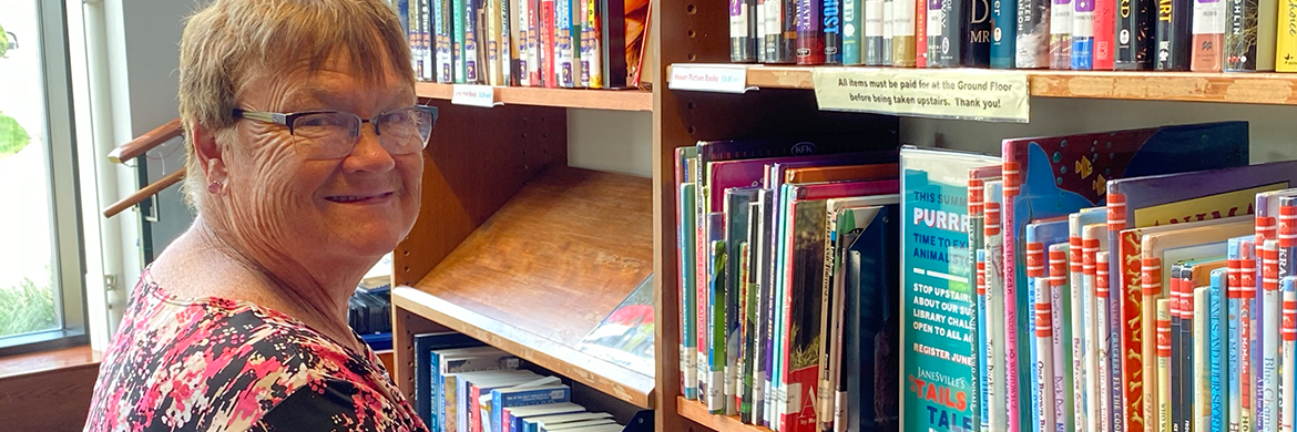 Volunteer smiling as she shelves books