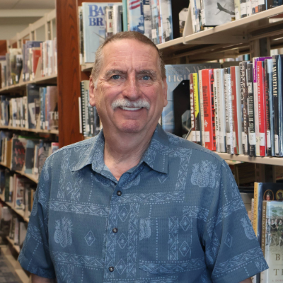 man with short hair and a mustache smiling at camera